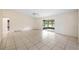 Large, sunlit living room with tile flooring, ceiling fan and view of an enclosed porch at 15918 Summit Ct, Clermont, FL 34711