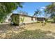 A grassy backyard with views of the home, a brick foundation, trees and shrubbery at 1639 W Schwartz Blvd, The Villages, FL 32159