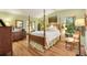 Spacious bedroom with wood floors, four-poster bed, and plenty of natural light at 1639 W Schwartz Blvd, The Villages, FL 32159