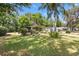 Manicured front yard with palm trees and other plants and shrubbery at 1639 W Schwartz Blvd, The Villages, FL 32159