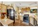 Functional kitchen with stainless steel appliances and wood-look cabinetry at 1639 W Schwartz Blvd, The Villages, FL 32159