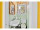 Small bathroom featuring a sink, toilet, window, and framed mirror with bright wallpaper and painted walls at 16724 Highland Ave, Montverde, FL 34756