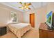 Cozy bedroom with a ceiling fan, natural light, and comfortable furnishings at 16724 Highland Ave, Montverde, FL 34756