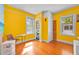 Bright bedroom with hardwood floors, yellow walls, windows, closet, and a view into an adjacent bathroom at 16724 Highland Ave, Montverde, FL 34756