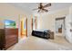 Bedroom featuring ceiling fan, wood shutters, neutral carpet and dresser with television at 16724 Highland Ave, Montverde, FL 34756
