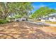 Property features an outbuilding with carports, lush trees, and a long driveway at 16724 Highland Ave, Montverde, FL 34756