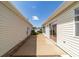 Side yard features well-kept plants and slider at 1706 Moreno Pl, The Villages, FL 32159