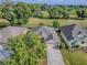Aerial view of a home with a well-manicured lawn and mature trees at 1741 Pennecamp Dr, The Villages, FL 32162