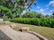 A backyard with brick pavers, mature landscaping, and bright sunlight at 1741 Pennecamp Dr, The Villages, FL 32162