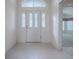 Bright foyer featuring tile floors, white walls, and a door with decorative glass at 1741 Pennecamp Dr, The Villages, FL 32162