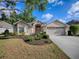 Charming home featuring manicured lawn, mature trees, neutral paint, and an attached two car garage at 1741 Pennecamp Dr, The Villages, FL 32162