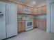 A spacious kitchen with tile flooring, white appliances, and light-tone cabinets at 1741 Pennecamp Dr, The Villages, FL 32162