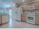 Bright kitchen features tile floor, white appliances, and light wood cabinets at 1741 Pennecamp Dr, The Villages, FL 32162