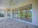 Large patio area with ceiling fan, tiled flooring, and large sliding glass doors at 1741 Pennecamp Dr, The Villages, FL 32162