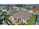 Aerial view showing a home's backyard, patio, screen enclosed patio, and landscaping at 1796 Zientara Loop, The Villages, FL 32163