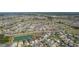 An aerial view showcases a community with homes surrounded by ponds and preserved green spaces at 1796 Zientara Loop, The Villages, FL 32163