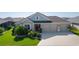 Charming home with a manicured lawn and landscaping, and a spacious three-car garage at 1796 Zientara Loop, The Villages, FL 32163