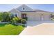 Charming single-story home showcasing a well-manicured lawn and a three-car garage, inviting curb appeal at 1796 Zientara Loop, The Villages, FL 32163