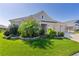 Well-maintained home with lush green lawn and vibrant landscaping adding to the curb appeal on a sunny day at 1796 Zientara Loop, The Villages, FL 32163
