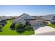 Well-maintained home with lush landscaping, a three-car garage, and inviting curb appeal at 1796 Zientara Loop, The Villages, FL 32163