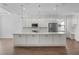 Modern kitchen with stainless appliances, a large center island, and white cabinetry offers a bright and open design at 1796 Zientara Loop, The Villages, FL 32163