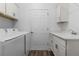 Well-equipped laundry room with washer, dryer, sink, and storage cabinets at 1796 Zientara Loop, The Villages, FL 32163