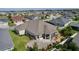 Beautiful home featuring a screened lanai, stone patio, lush landscaping, and a view of the neighborhood at 1796 Zientara Loop, The Villages, FL 32163