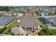 Expansive home featuring a screened lanai, stone patio, lush landscaping, and beautiful neighborhood lake view at 1796 Zientara Loop, The Villages, FL 32163
