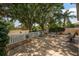 An expansive backyard with a white picket fence offers serene views and shaded seating at 1814 Marquez Loop, The Villages, FL 32159