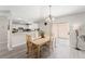 Bright dining area adjacent to the kitchen featuring a wood table, chandelier, and sliding glass doors at 1814 Marquez Loop, The Villages, FL 32159