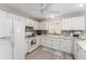Well-lit kitchen featuring white cabinets, marble countertops, and modern appliances at 1814 Marquez Loop, The Villages, FL 32159