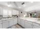 Bright kitchen featuring white cabinets, marble countertops, and seamless flow into the living area at 1814 Marquez Loop, The Villages, FL 32159