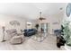 Inviting living room with a plush blue sofa, recliner, and sliding doors to the patio at 1814 Marquez Loop, The Villages, FL 32159