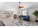 Comfortable living room featuring a blue sofa, stylish ceiling fan, and access to the dining area at 1814 Marquez Loop, The Villages, FL 32159
