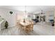 Open-concept living room with hardwood floors, modern furnishings, and a bright dining area at 1814 Marquez Loop, The Villages, FL 32159