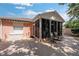 Enclosed patio with screen windows and furniture, next to a storage box at 1814 Marquez Loop, The Villages, FL 32159