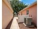 A narrow walkway runs between two homes with stone and an outdoor air conditioner at 1814 Marquez Loop, The Villages, FL 32159