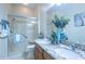Bright bathroom featuring a double sink vanity with granite countertops and a glass-enclosed shower at 1954 Ladyfish Ave, The Villages, FL 32162