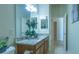 Hallway view of the bathroom, highlighting a granite vanity and a decorative mirror at 1954 Ladyfish Ave, The Villages, FL 32162
