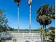 Scenic view of lush golf course framed by palm trees and a white picket fence at 1954 Ladyfish Ave, The Villages, FL 32162