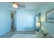An airy main bedroom featuring serene light blue walls and a partial view of the white bed at 1954 Ladyfish Ave, The Villages, FL 32162