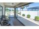 A cozy screened-in patio featuring sliding glass doors and views of the green backyard and nearby fence at 1954 Ladyfish Ave, The Villages, FL 32162