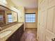 Bright bathroom featuring a granite countertop, dual sinks, and tile flooring at 2037 Lakeshore Dr, Mount Dora, FL 32757