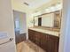 Bathroom featuring dual sinks with granite countertops, dark cabinets, and tile flooring at 2037 Lakeshore Dr, Mount Dora, FL 32757