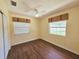 Bedroom with wood-look flooring, neutral paint, two windows and a ceiling fan at 2037 Lakeshore Dr, Mount Dora, FL 32757