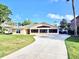 Charming single-story home featuring a well-manicured lawn and long concrete driveway at 2037 Lakeshore Dr, Mount Dora, FL 32757