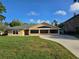 Tan single-story home featuring a well-maintained lawn and a concrete driveway at 2037 Lakeshore Dr, Mount Dora, FL 32757