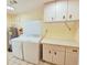Laundry room with washer, dryer, storage cabinets and a utility sink at 2037 Lakeshore Dr, Mount Dora, FL 32757