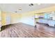 Open-concept living room featuring hardwood floors and a view of the kitchen with white cabinetry at 2037 Lakeshore Dr, Mount Dora, FL 32757