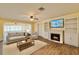 Cozy living room with fireplace, built-in bookshelves, and adjacent sunroom at 2037 Lakeshore Dr, Mount Dora, FL 32757